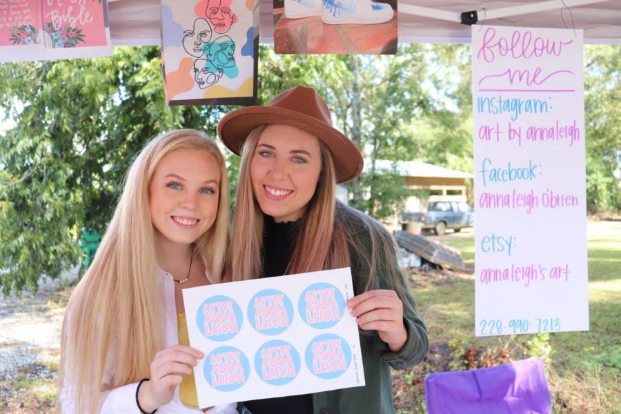 Senior Anna Leigh OBrien sells her artwork at a recent art show with her sister Blakely.