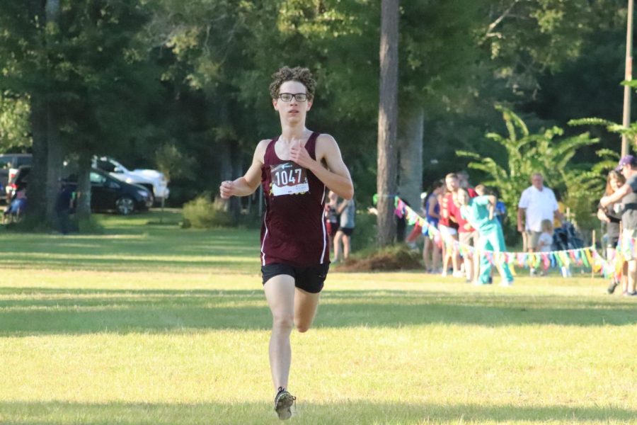 Ethan Fisher finishes first in home cross country meet.