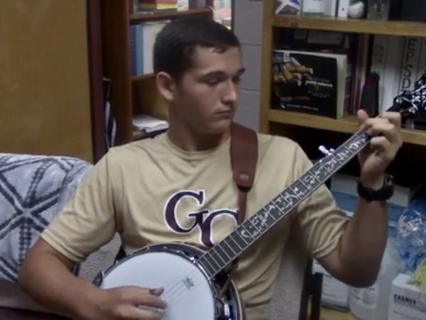 McMillan learns to play banjo