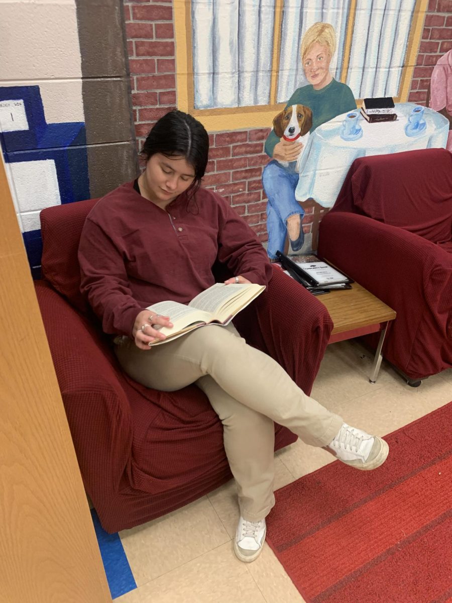 Junior Avery Box takes a quick break in the library to catch up on some reading. 